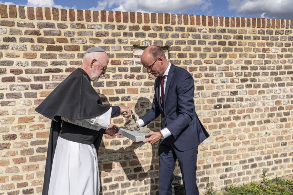 Kruisheer Edgar Claes en wethouder Joost Hendrikx metselen de laatste steen in