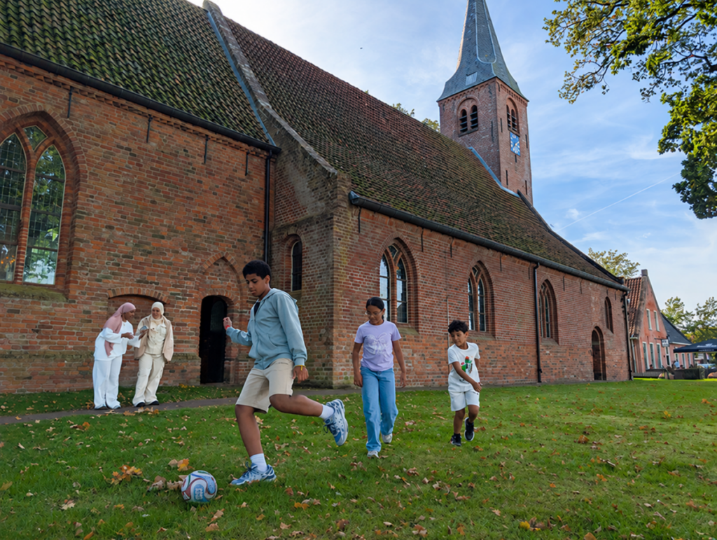 Campagnefoto actie onderdak voetballende kinderen bij een kerk